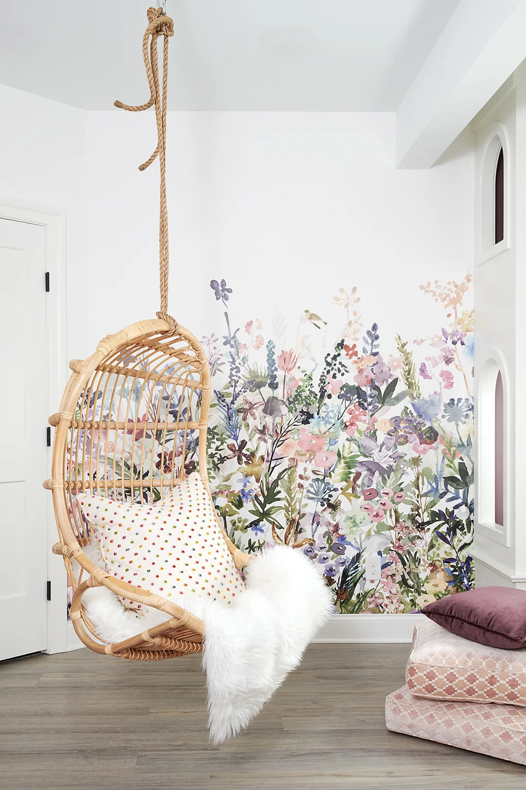 The floral mural on the left wall adds brightness to the space and includes all of the fun colors these girls love to tie together the room. Big, comfy floor pillows are great for adding softness for lounging. The luxury vinyl plank flooring also extends into this space for easy cleanup from art projects.