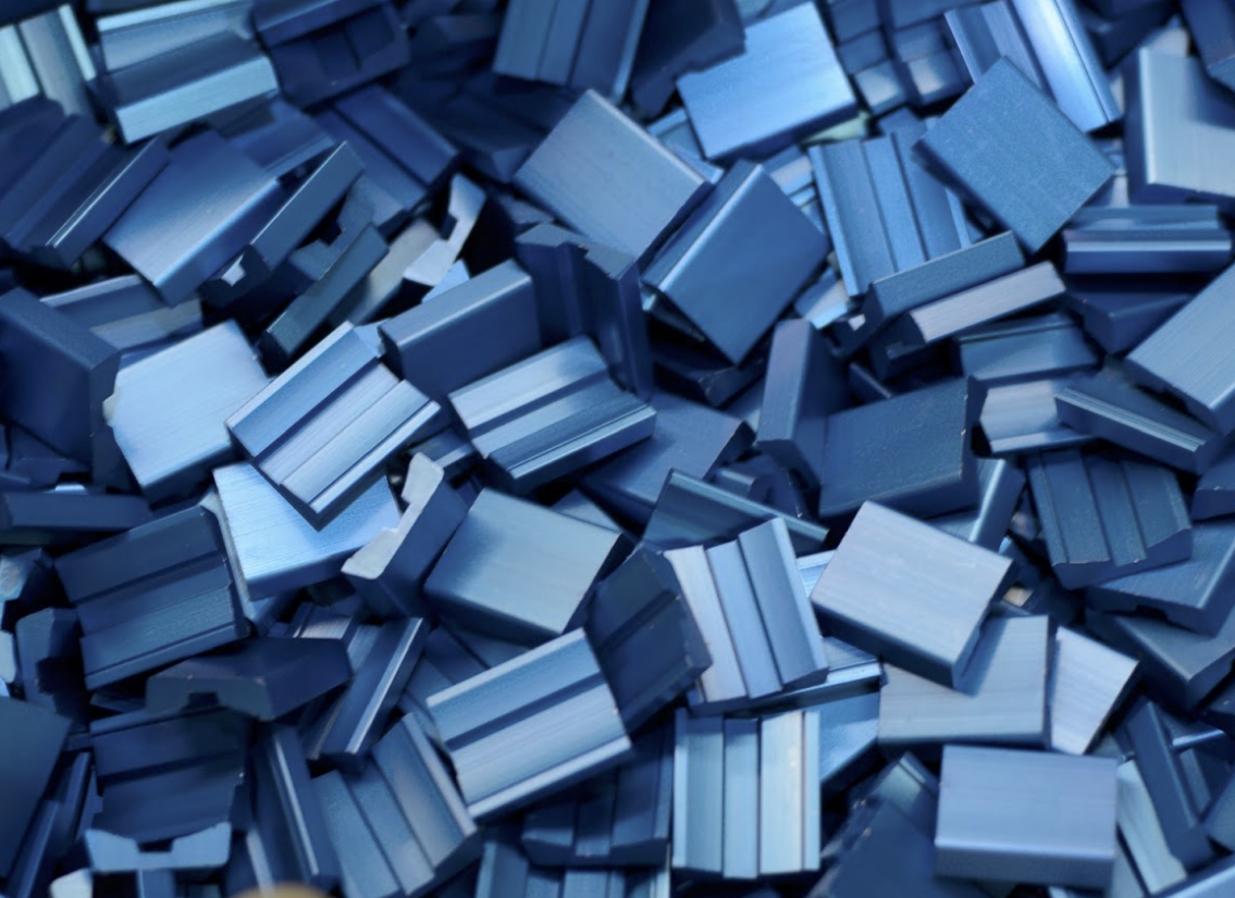 A pile of shiny blue metal square pieces.