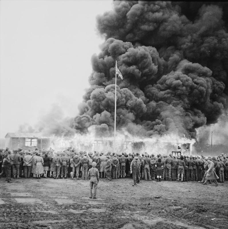 A crowd watches the destruction of the last camp hut