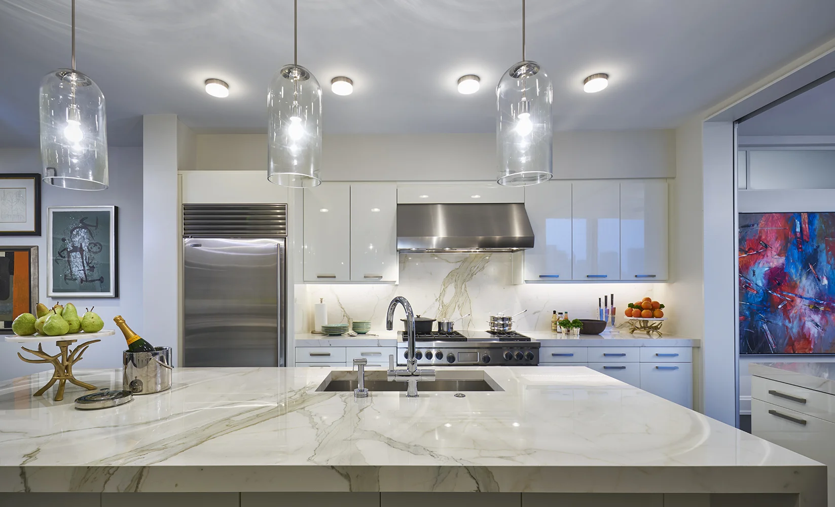 Three custom glass light fixtures from New Metal Crafts wash the island in light.