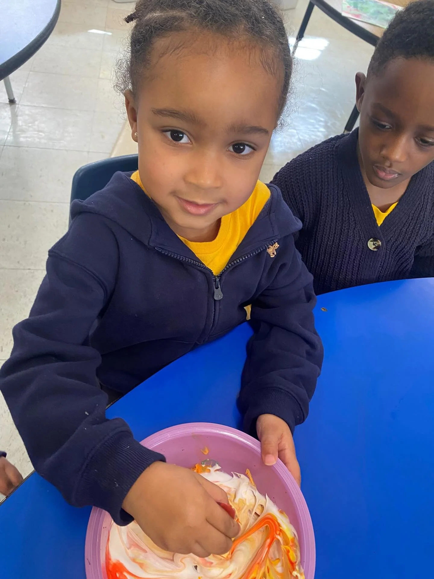 Pre-K students are actively engaged in a fun hands-on science experiment as they create space mud, exploring textures and materials through sensory play.