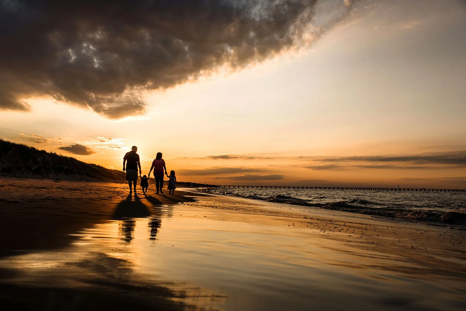 rolling-clouds-sunset-sky-family-silhouette-on-the-beach-melissa-bliss-photography-virginia-beach-photographer.jpg