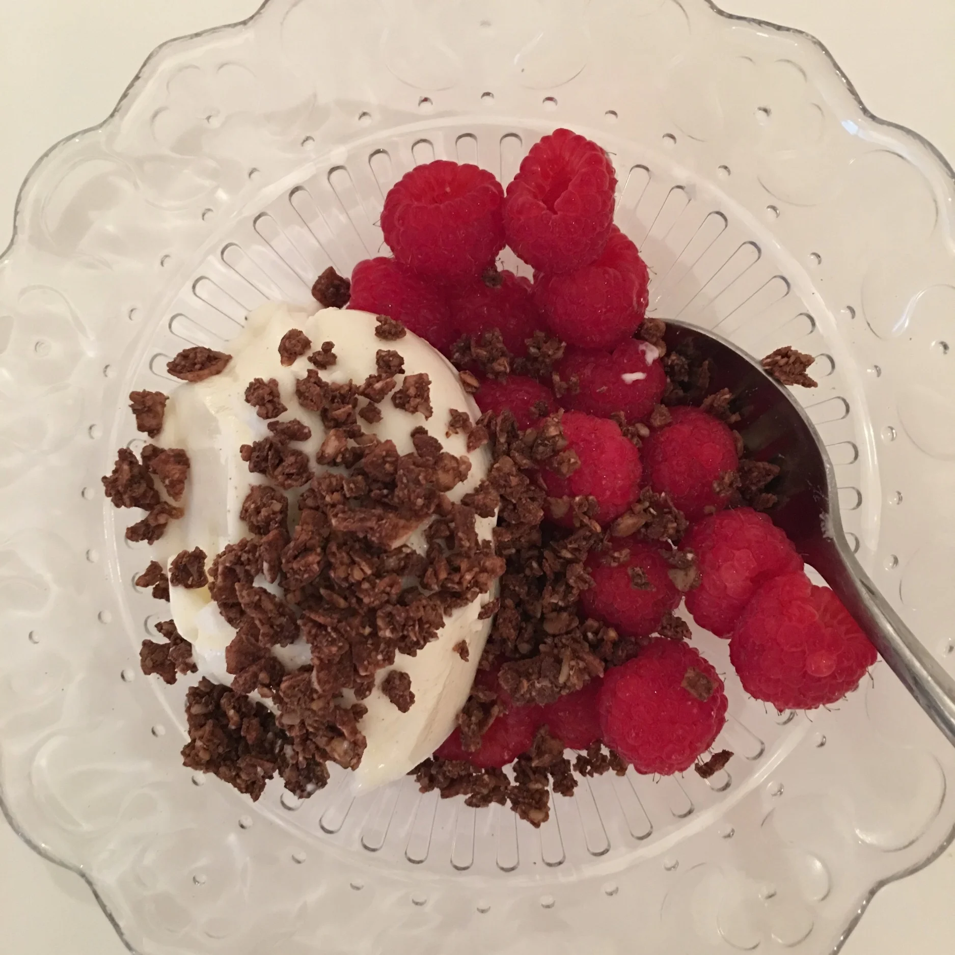 Almond Milk Yogurt Dessert with Cacao Sprinkles and Fresh Raspberries.
