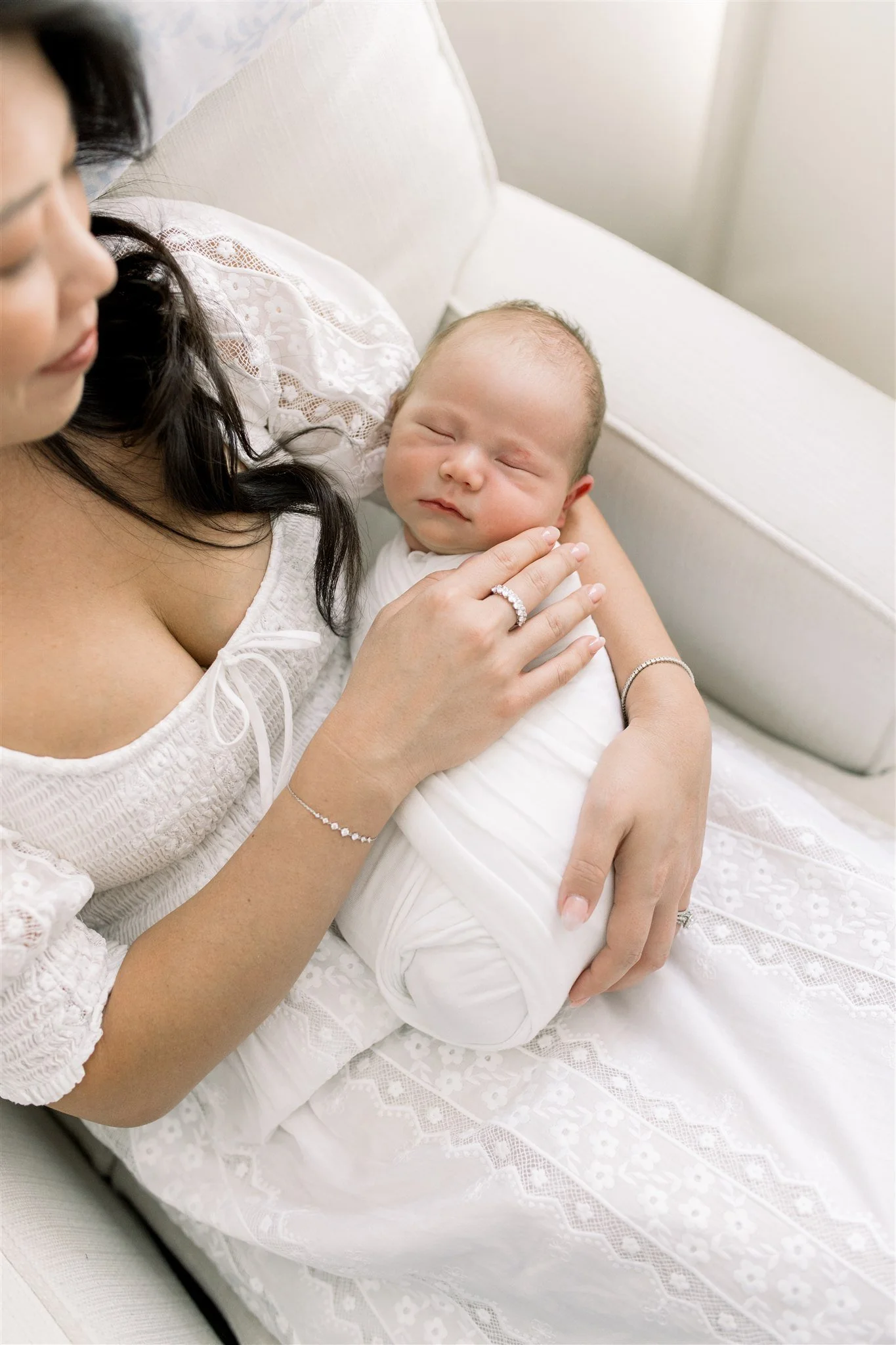 Baby swaddled asleep in mothers arms