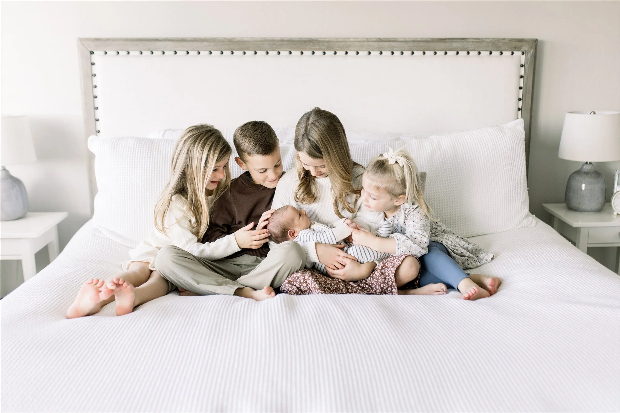 Four siblings hold their newest baby brother