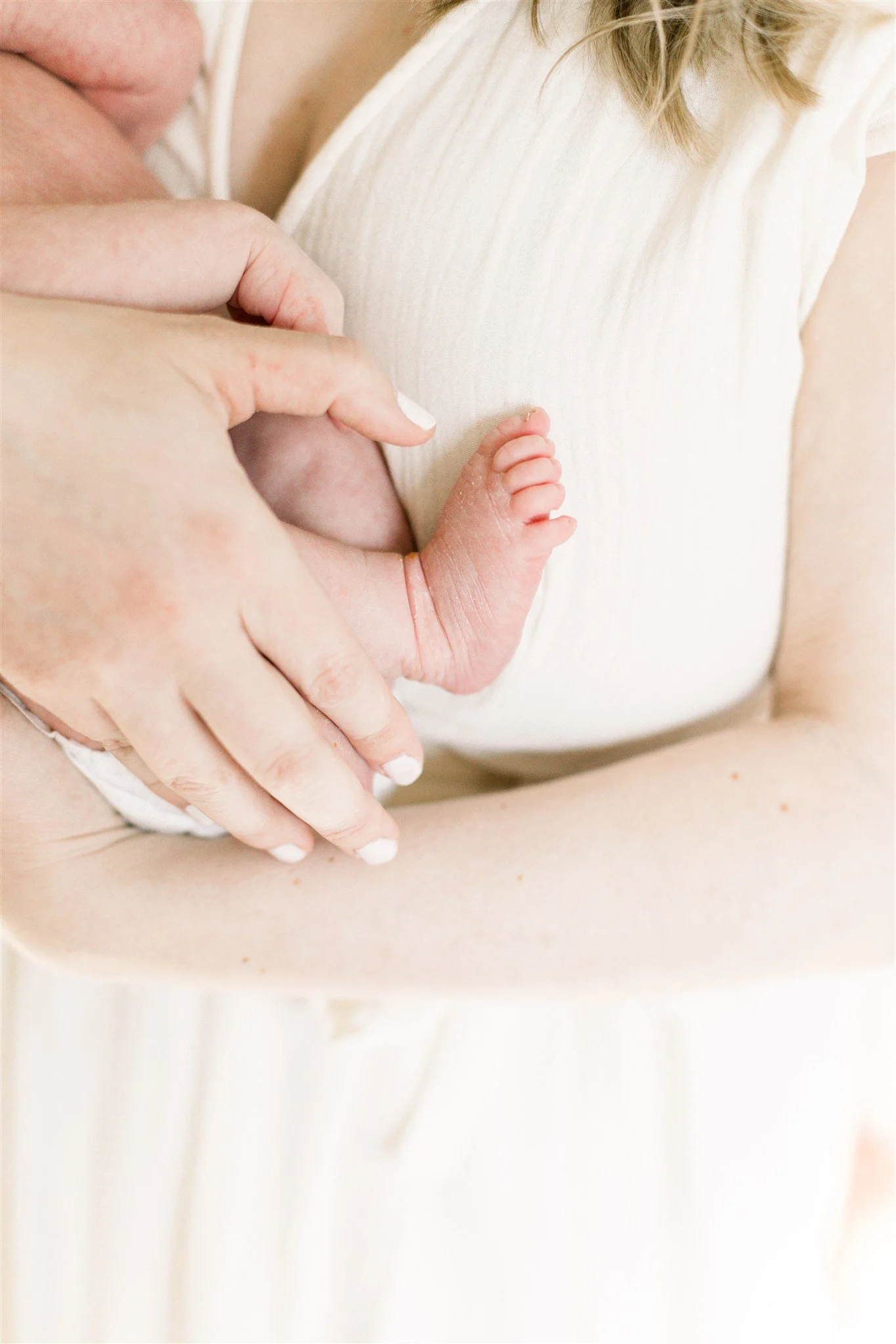 Newborn baby foot held in mothers hand
