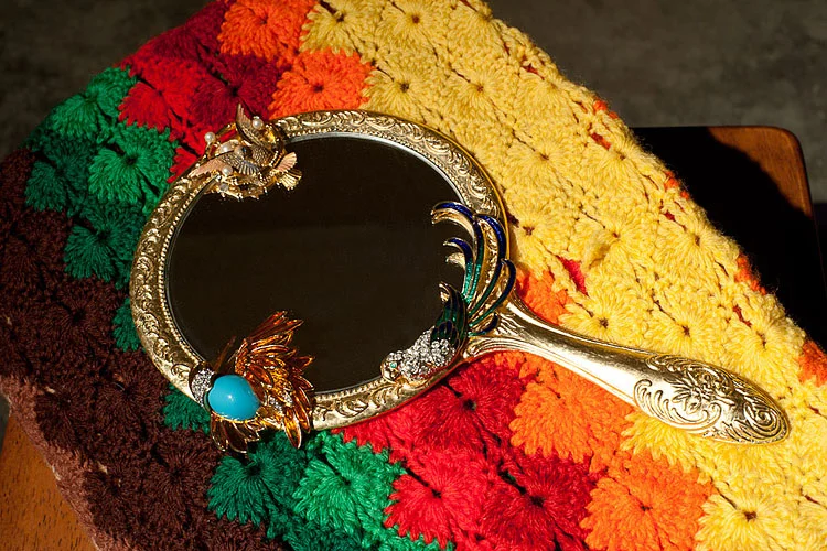 Pretty Bird, 2010–2011 / Assemblage of costume jewelry, hand mirror, gold leaf, found afghan
