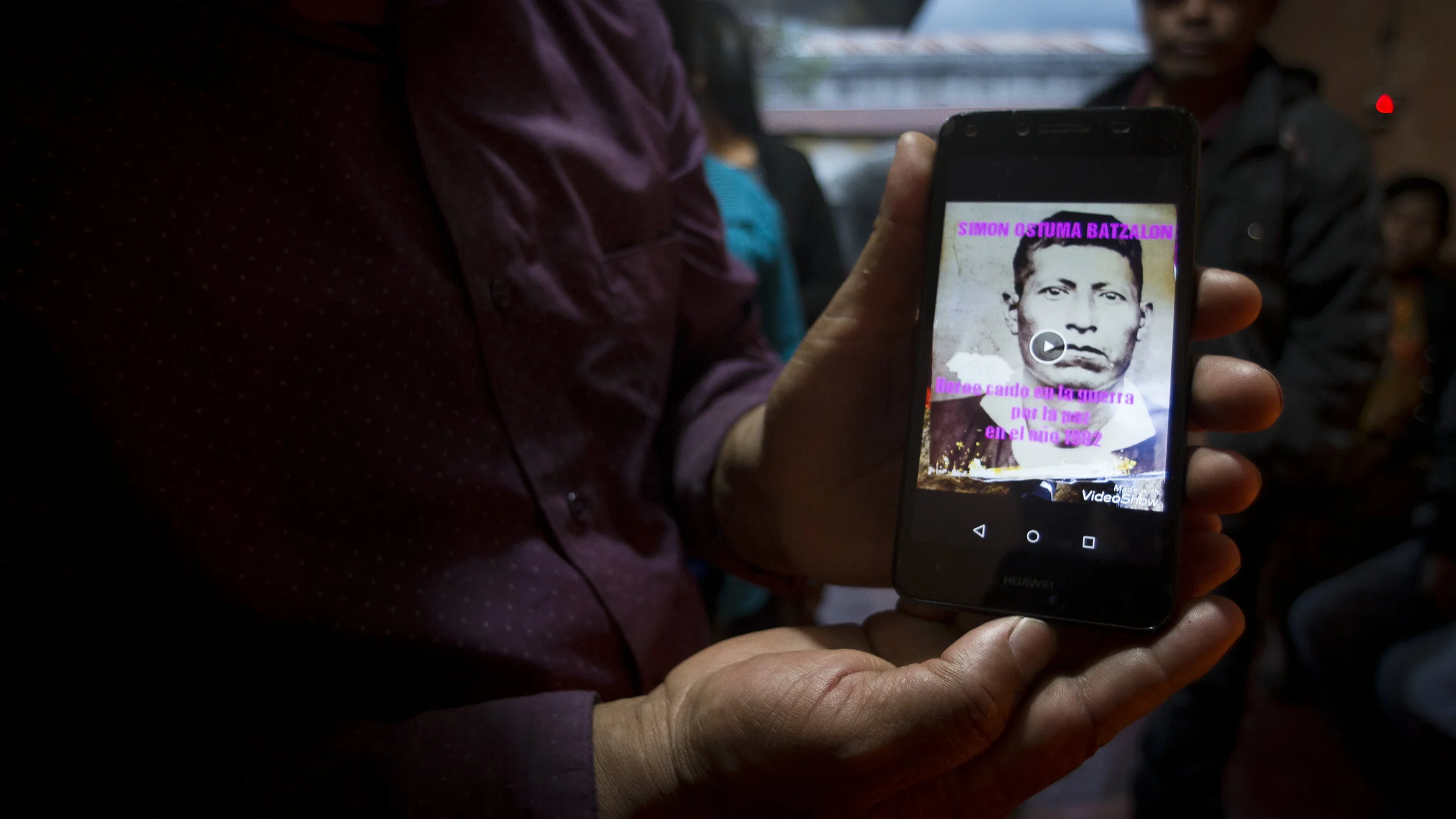 Juan Ostuma muestra en su telefono la fotografía de su padre Simón Ostuma, una de las victimas exhumadas.