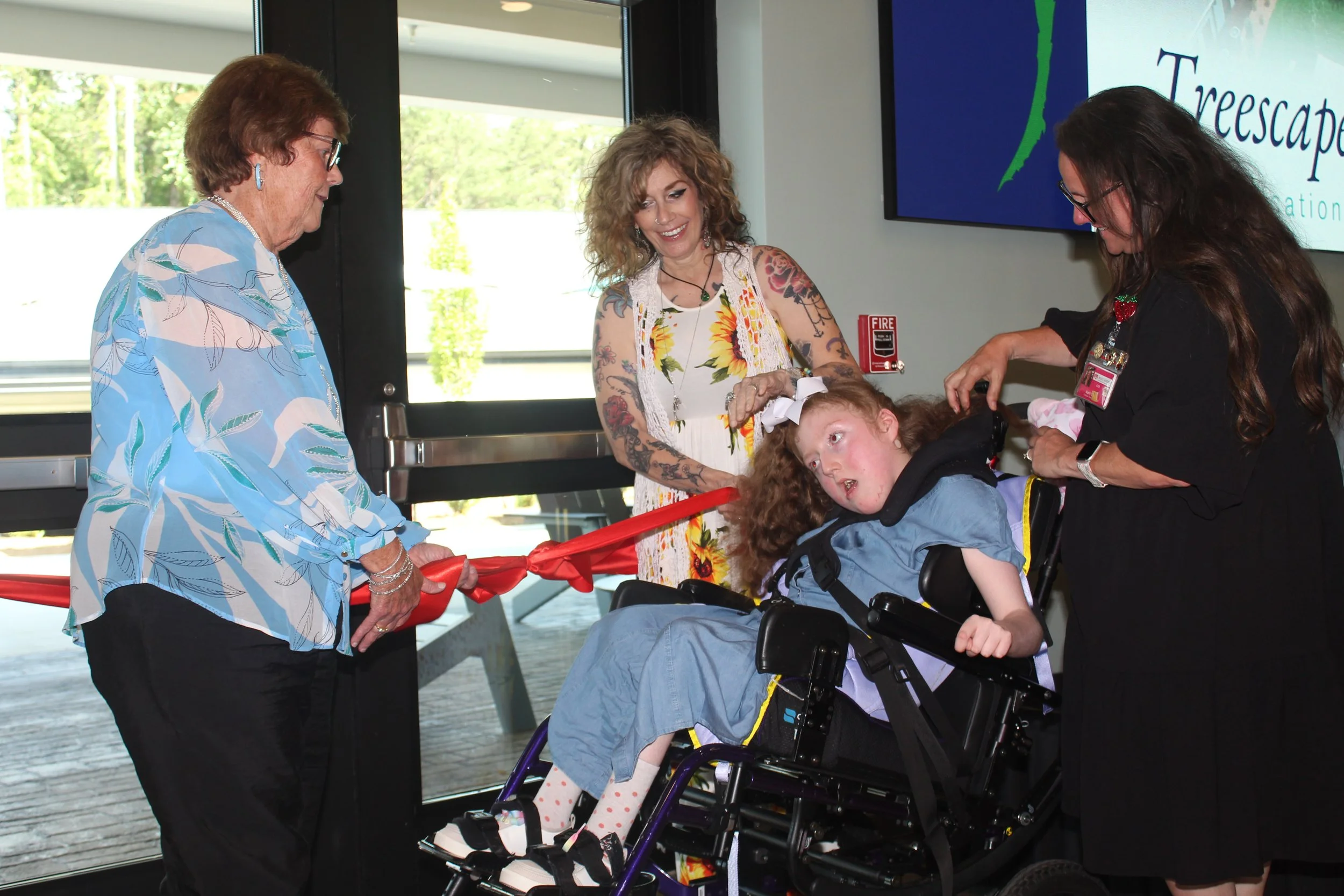 Regina Moody assists resident Nora with opening the bow.JPG