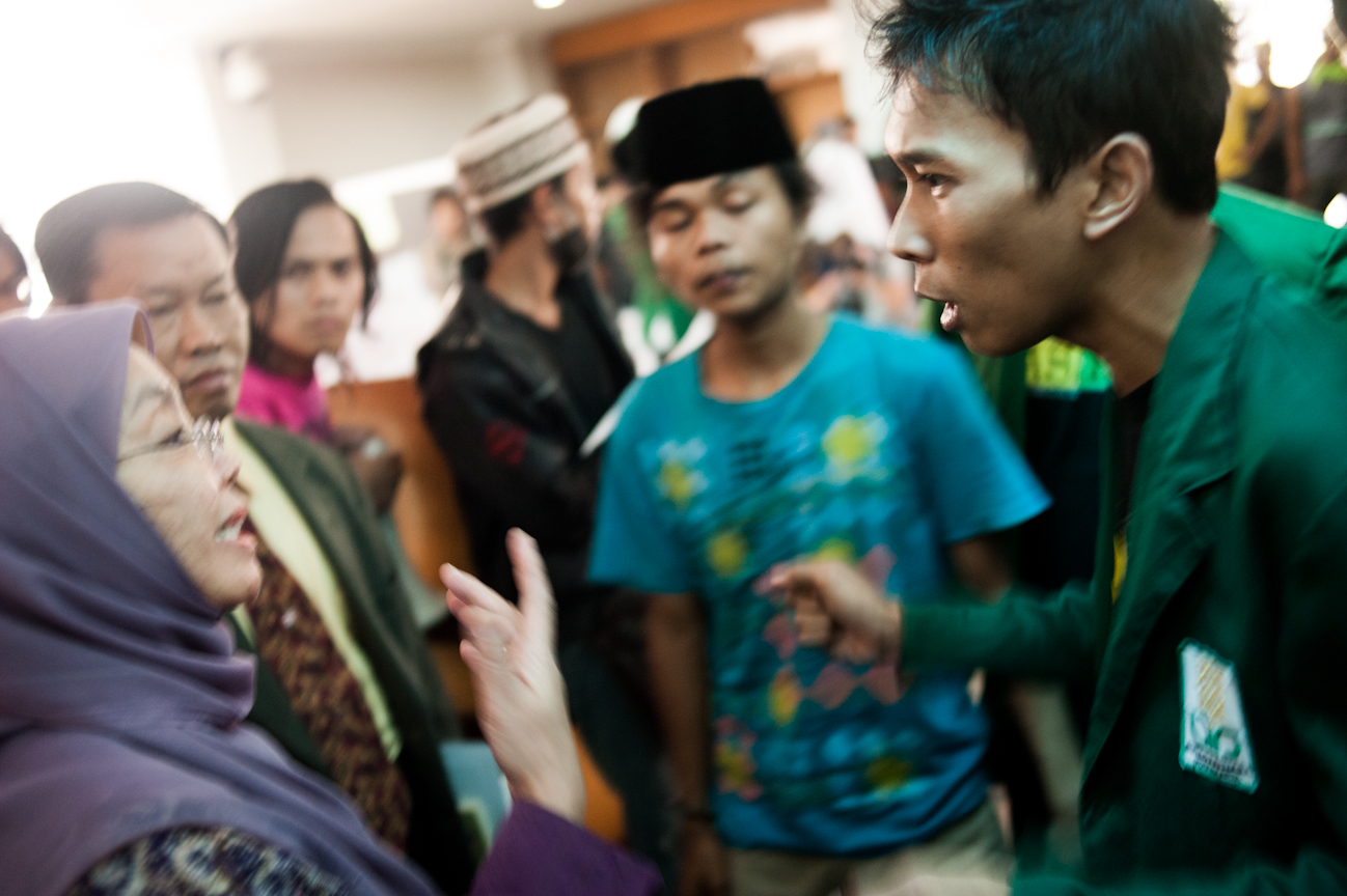 Okky debates with a member of the faculty at Universitas Islam Negeri about the injustice of the new school legislation. The demonstration continued for approximately an hour after the students had flooded into the head office building, demanding to see the highest member of faculty at the university. Upon pressing insistence by the student body, the director of the university signed a proposal drafted by PMII members to repeal the legislation, thus proving the demonstration a success.