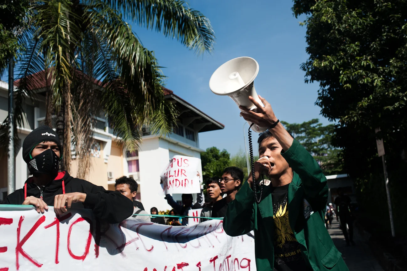 Okky leads the National Anthem of Indonesia during the peaceful demonstration against new school legislation at Universitas Islam Negeri.