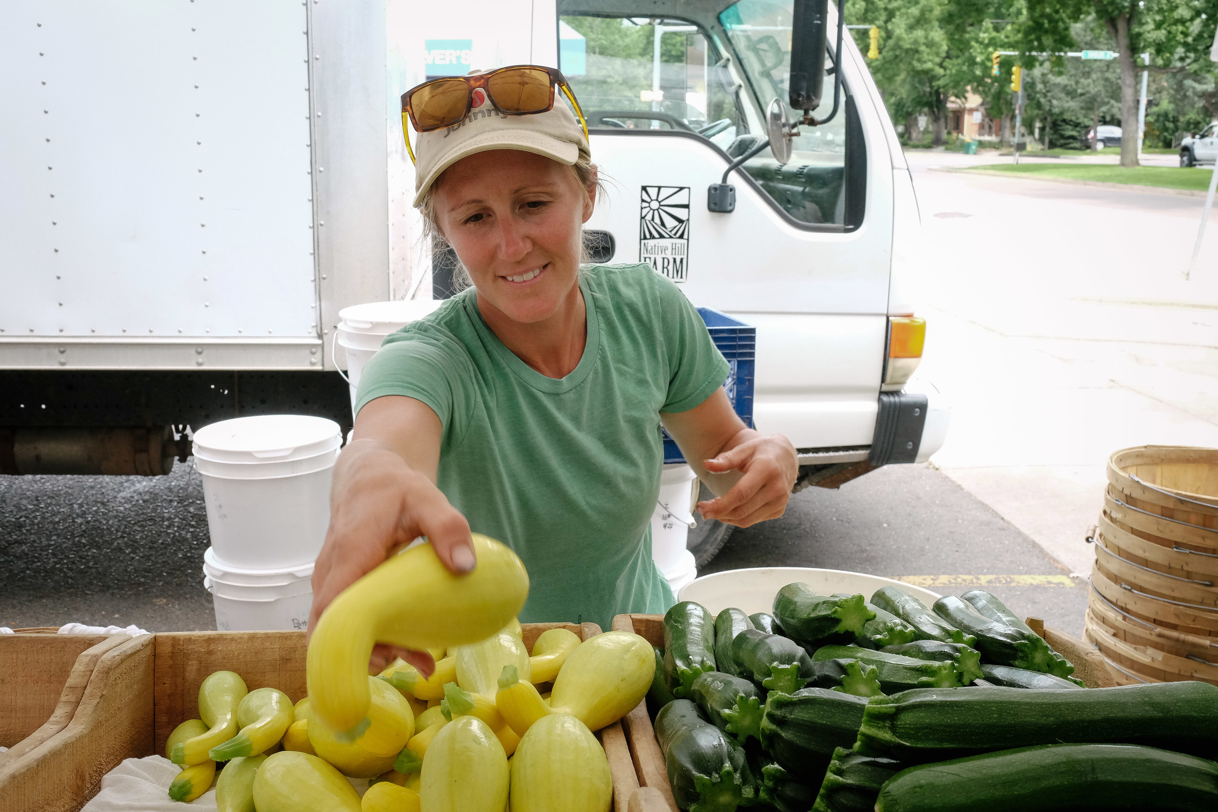 Katie Slota arranges squash at her farmer's market stand.