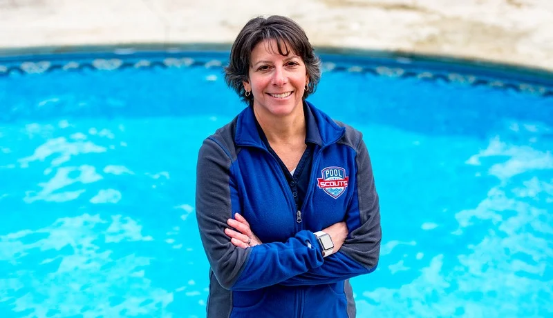 Pool Scouts owner Tiffiny Consoli standing in front of a clear blue pool.jpg