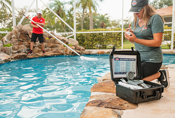 Pool Scouts franchise owners cleaning a pool