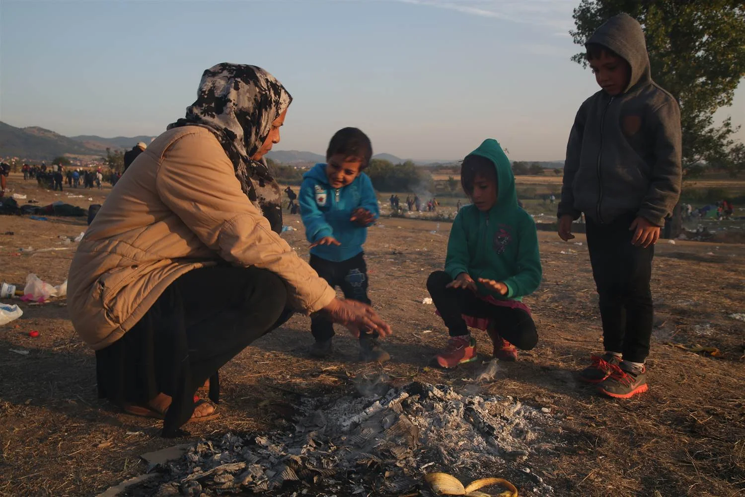 A Syrian refugee shows her grandchildren how to warm their hands by a fire after sleeping on the ground in Macedonia -- one stop on their journey to Germany.