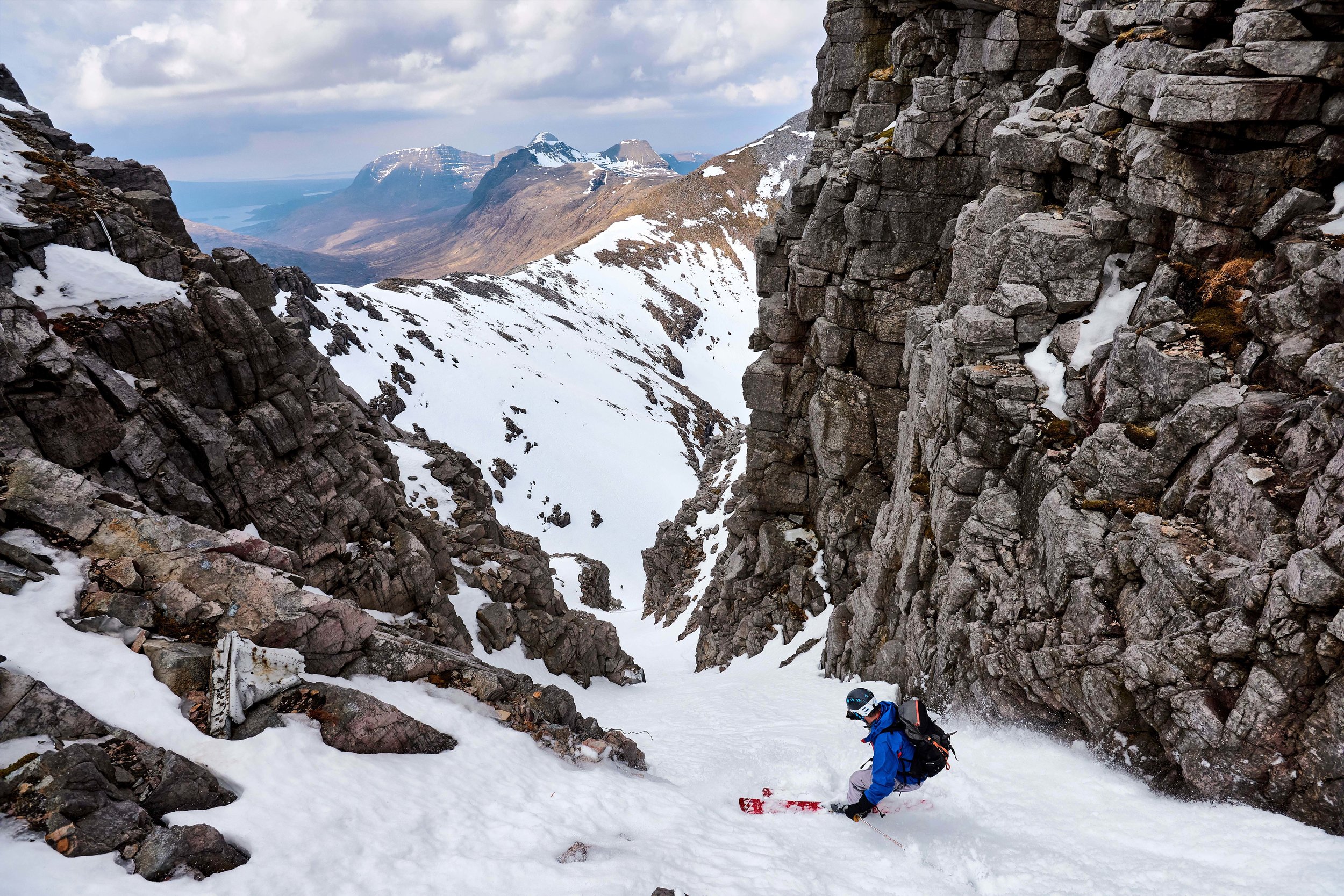 Scott skiing the narrow upper section of 'Fuselage Gully' on Beinn Eighe. In 1951, a Lancaster bomber crashed directly below the summit of Còinneach Mòr, one of the tops of Beinn Eighe and the gully is named after the wreckage which now sits within it (some of which can be seen in the photo). In lean snow conditions, a large propellor which is part of the wreckage can require an abseil to bypass, however on this occasion it was completely banked out, with only the top 30cm or so visible.