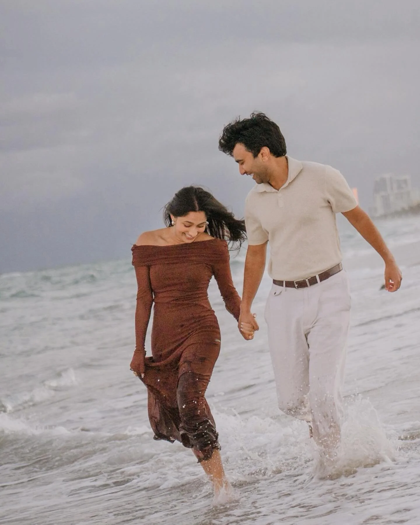 A little rain never scares me. I love the drama and those little breaks of sunshine through the clouds. This Hollywood FL beach engagement session had the dreamiest mix of moody skies, soft light, and that kind of weather that somehow makes everythin