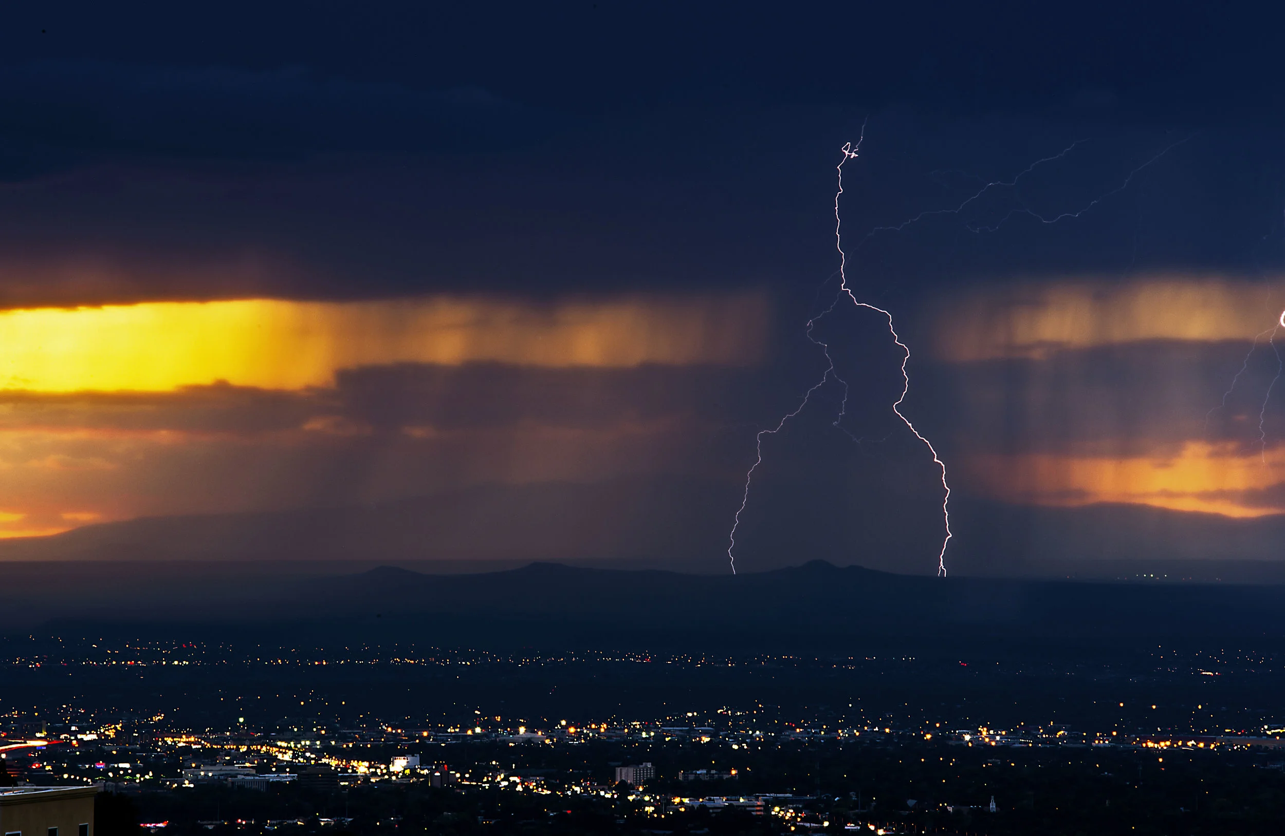 Lightning Striking down on the "three sisters"(three dormant volcanoes), in Albuquerque NM.