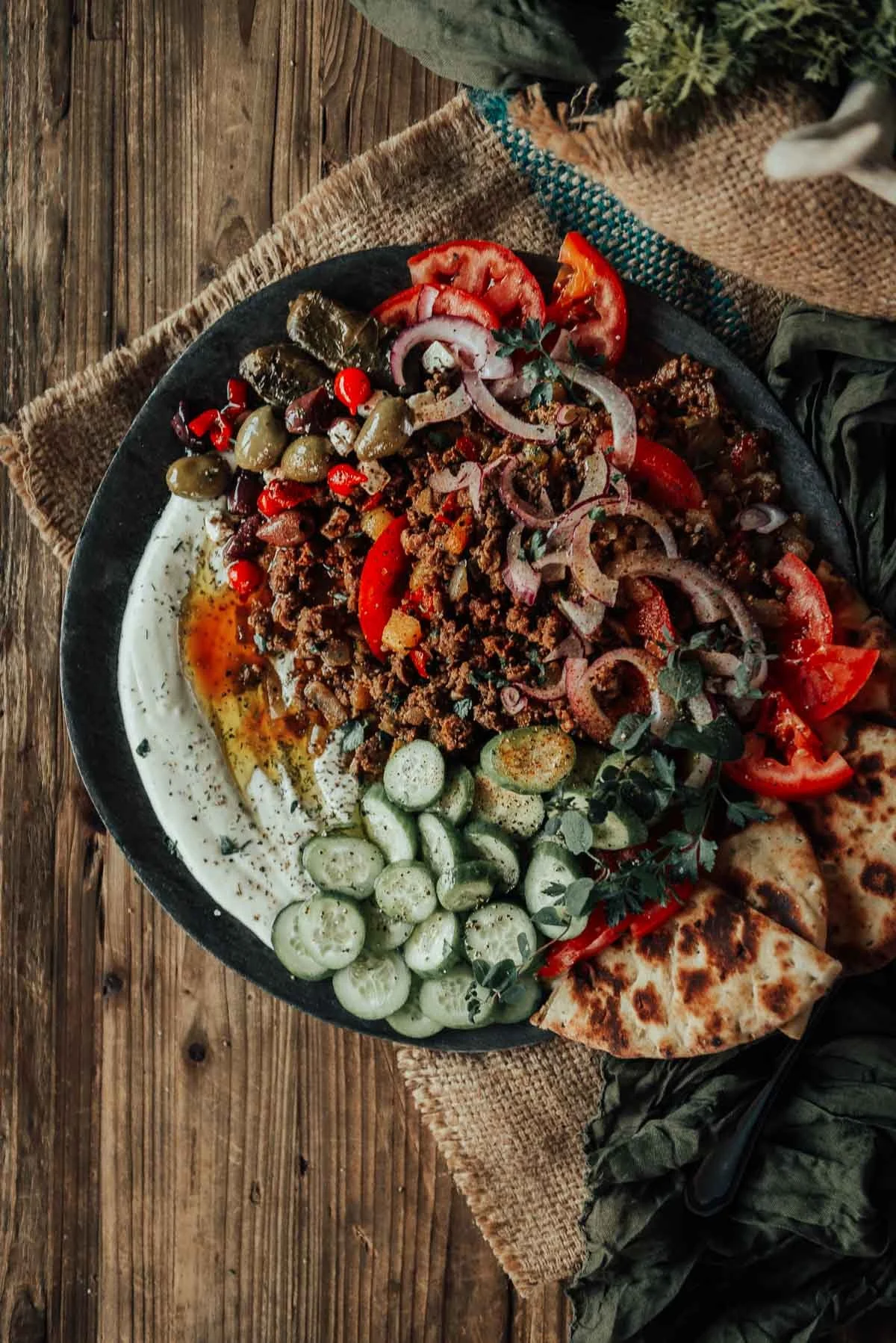 Greek ground lamb on a plate over whipped ricotta.