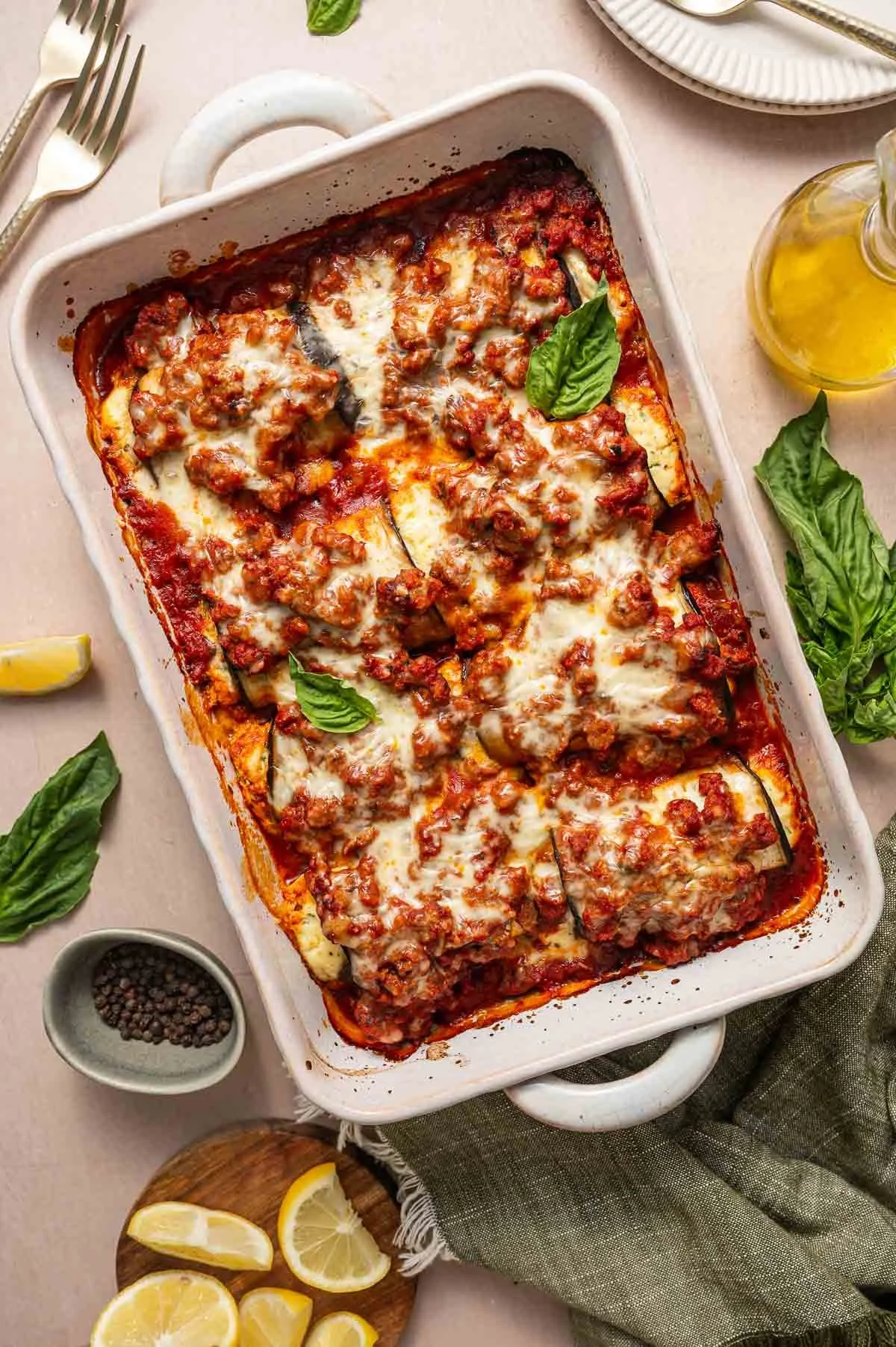 Lamb Eggplant Rollatini in a baking dish garnished with fresh basil.