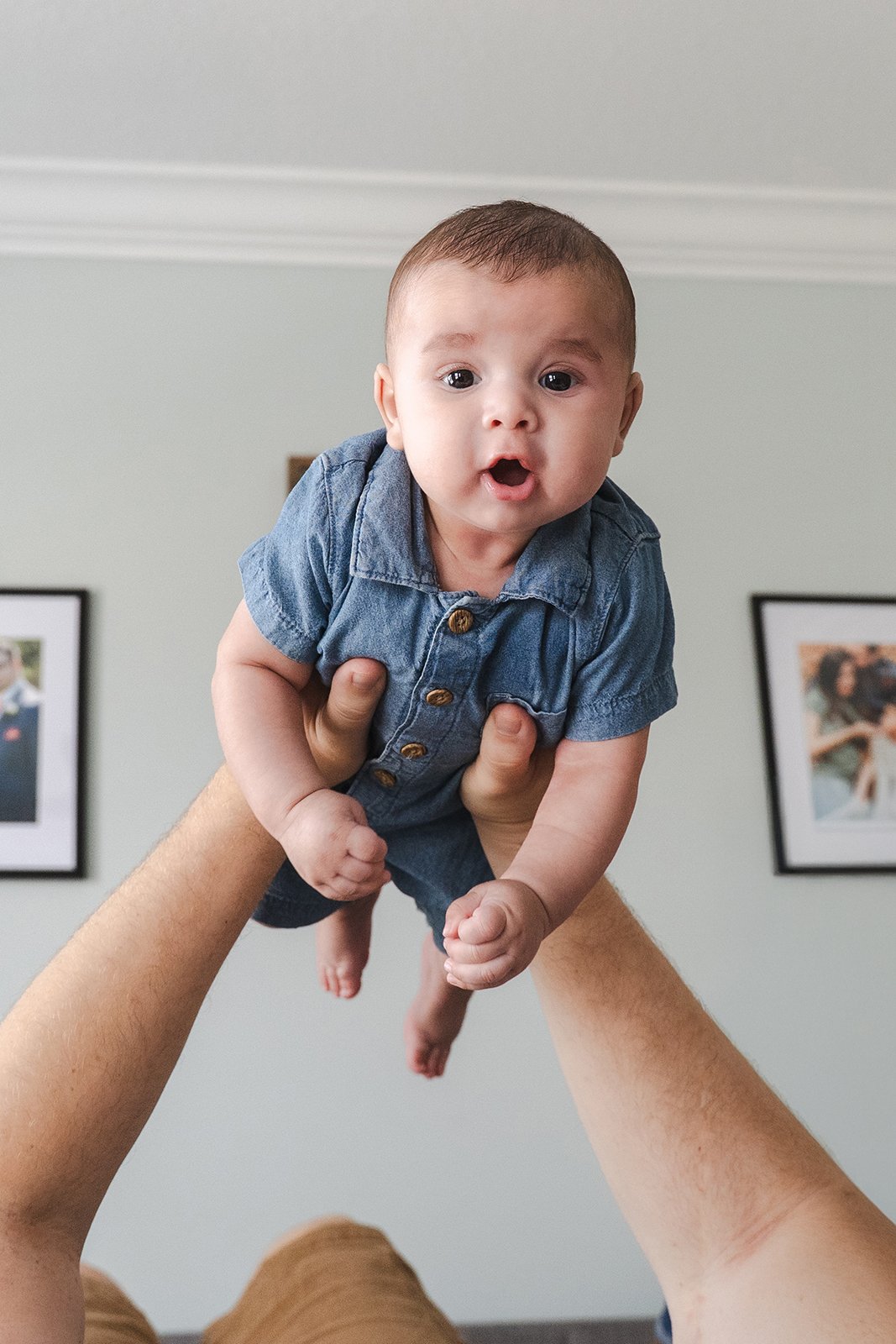Closeup of baby boy held above his dad in their Clarksville, TN home..