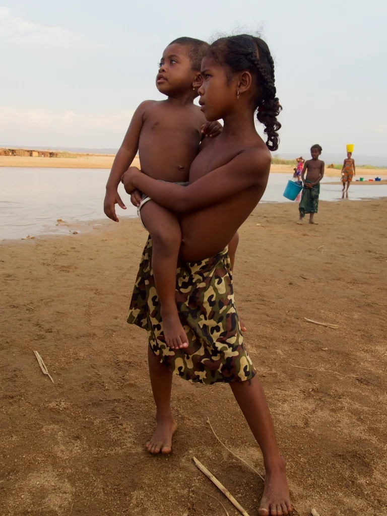 A girl and her sister observe the spectacle of aliens from another planet canoeing into their village. In rural Madagascar 'raza', or white ones elicit surprise.
