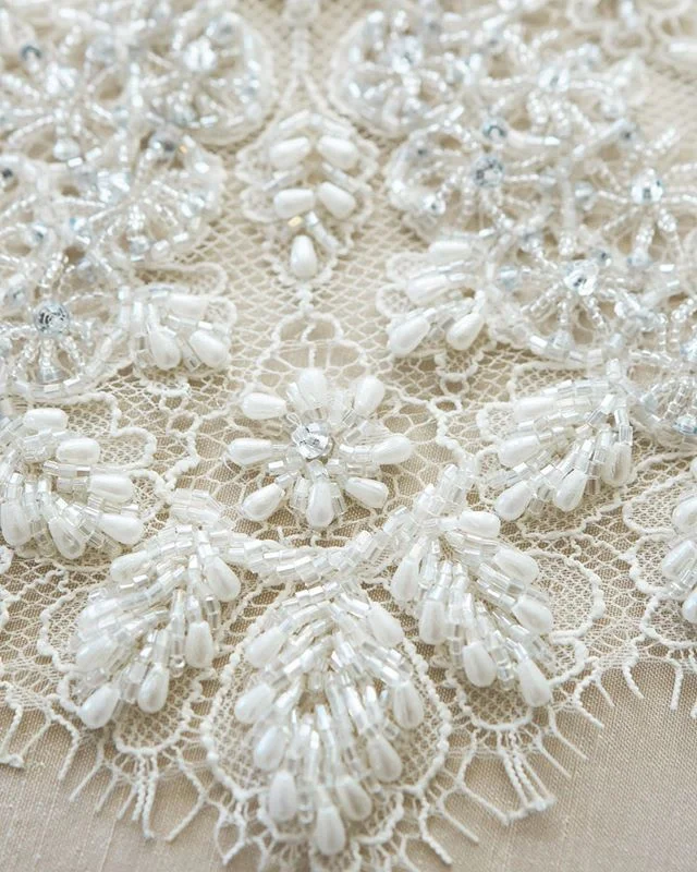 This beautiful lace trim features sparkling hand beaded silver and ivory beading and will be online soon and ready to purchase! #lace #designerlace #fabricstore #bridallace #madebyhand #handbeading