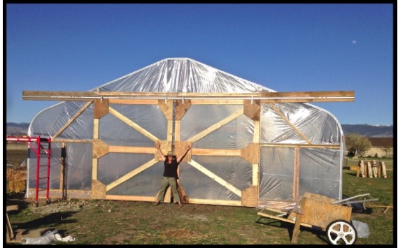 Small farmer, big dreams. Mary stands at the entrance to the newly built--and very large--sliding hoophouse doors.