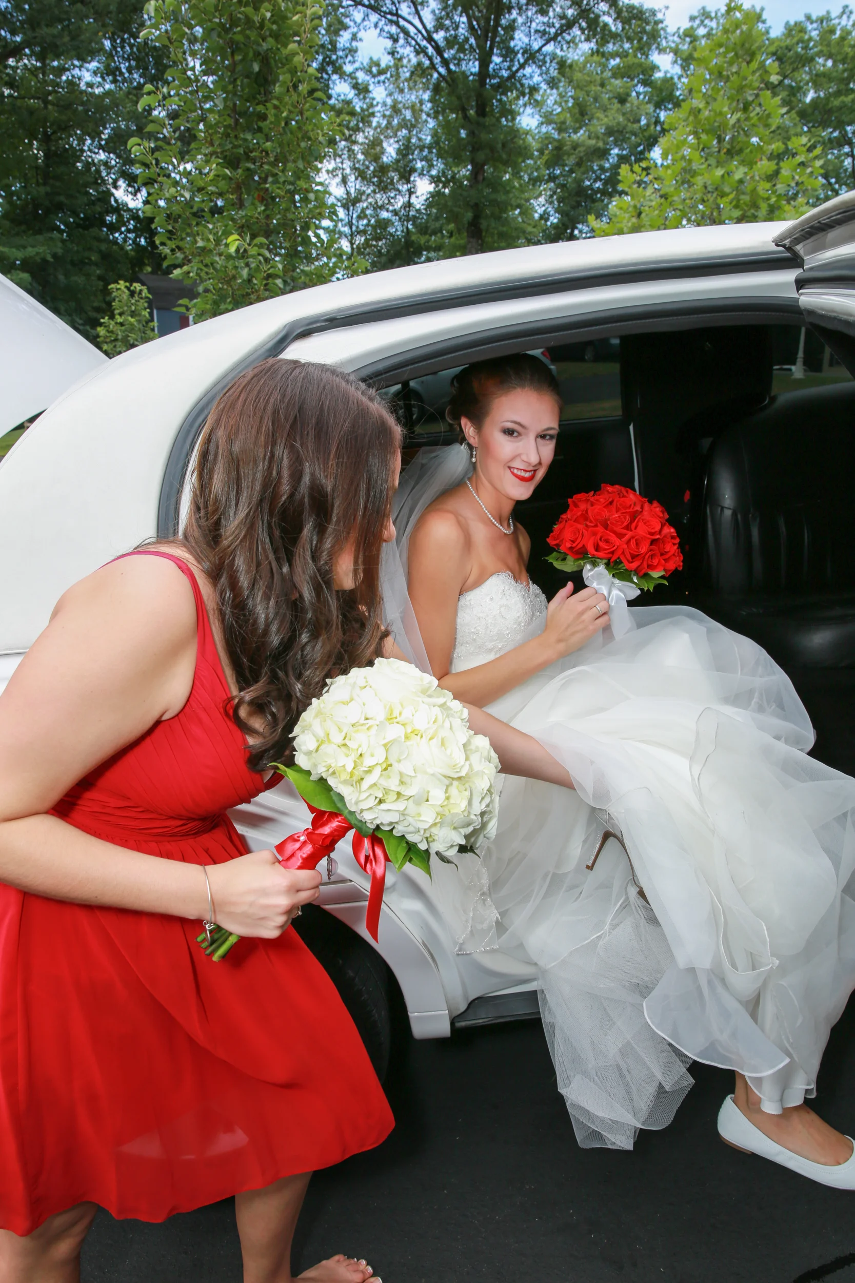 Sister of the bride helping her into the limo