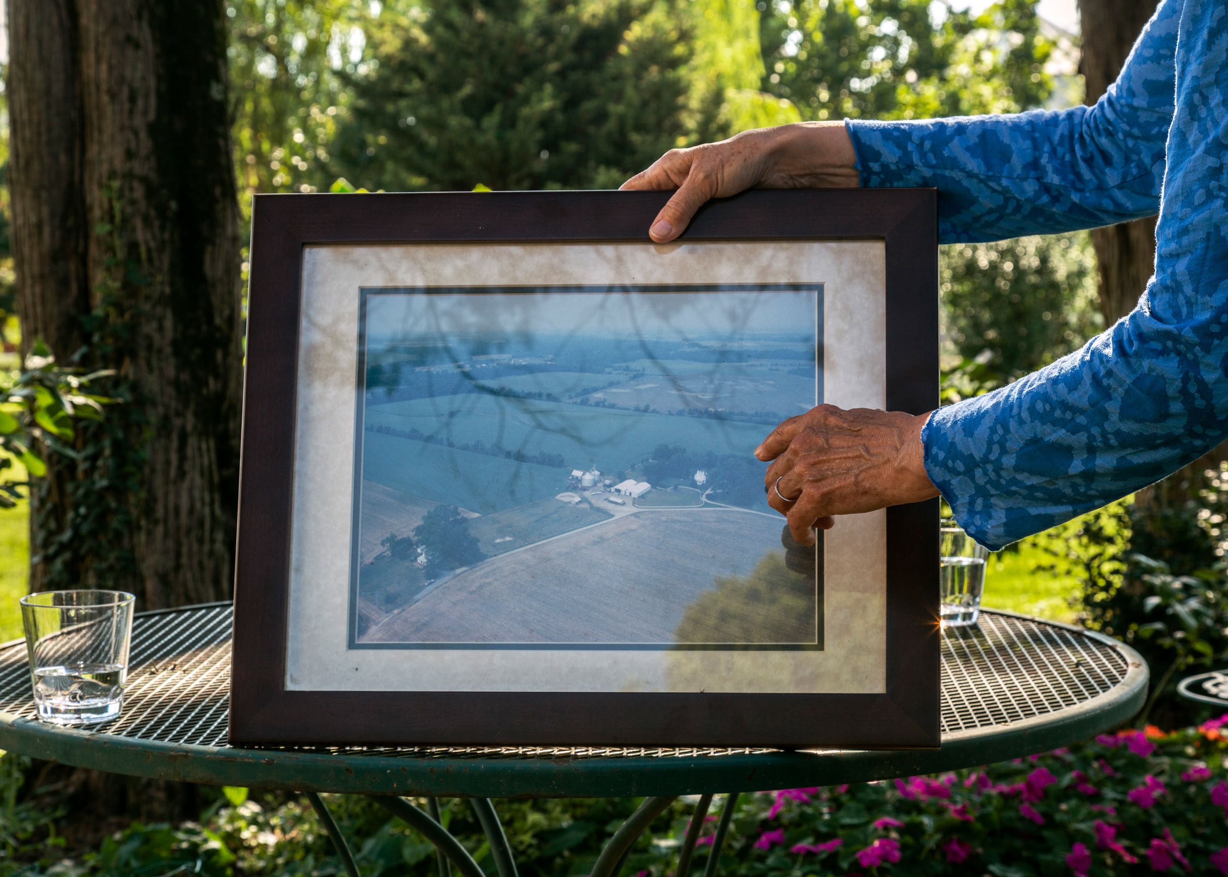 Anne Haberton displays an aerial photo of much of the farm taken in the early 2000's