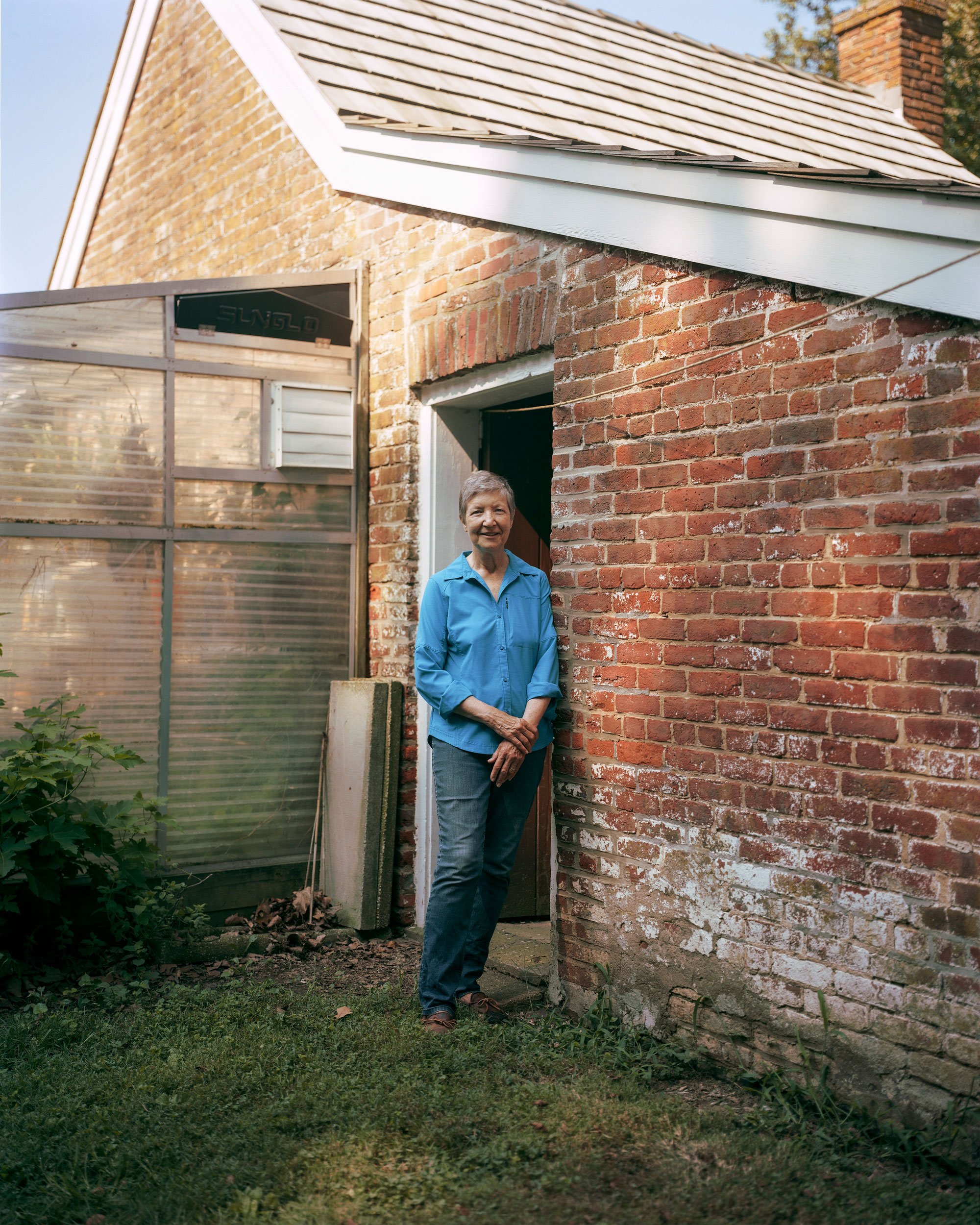 Anne stands in a doorway to the old smokehouse