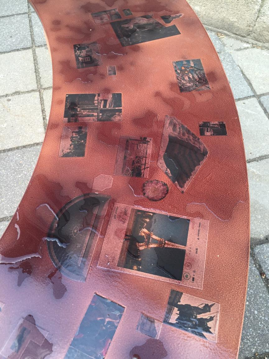 The bench tops are collaged with images that exhibit the mutable symbolism inherent in public works. A thermal paint has been applied to the furniture tops to respond not only to weather but also to the human touch. Both the sun and the body have the potential to reveal the constellation of images beneath the paint. 