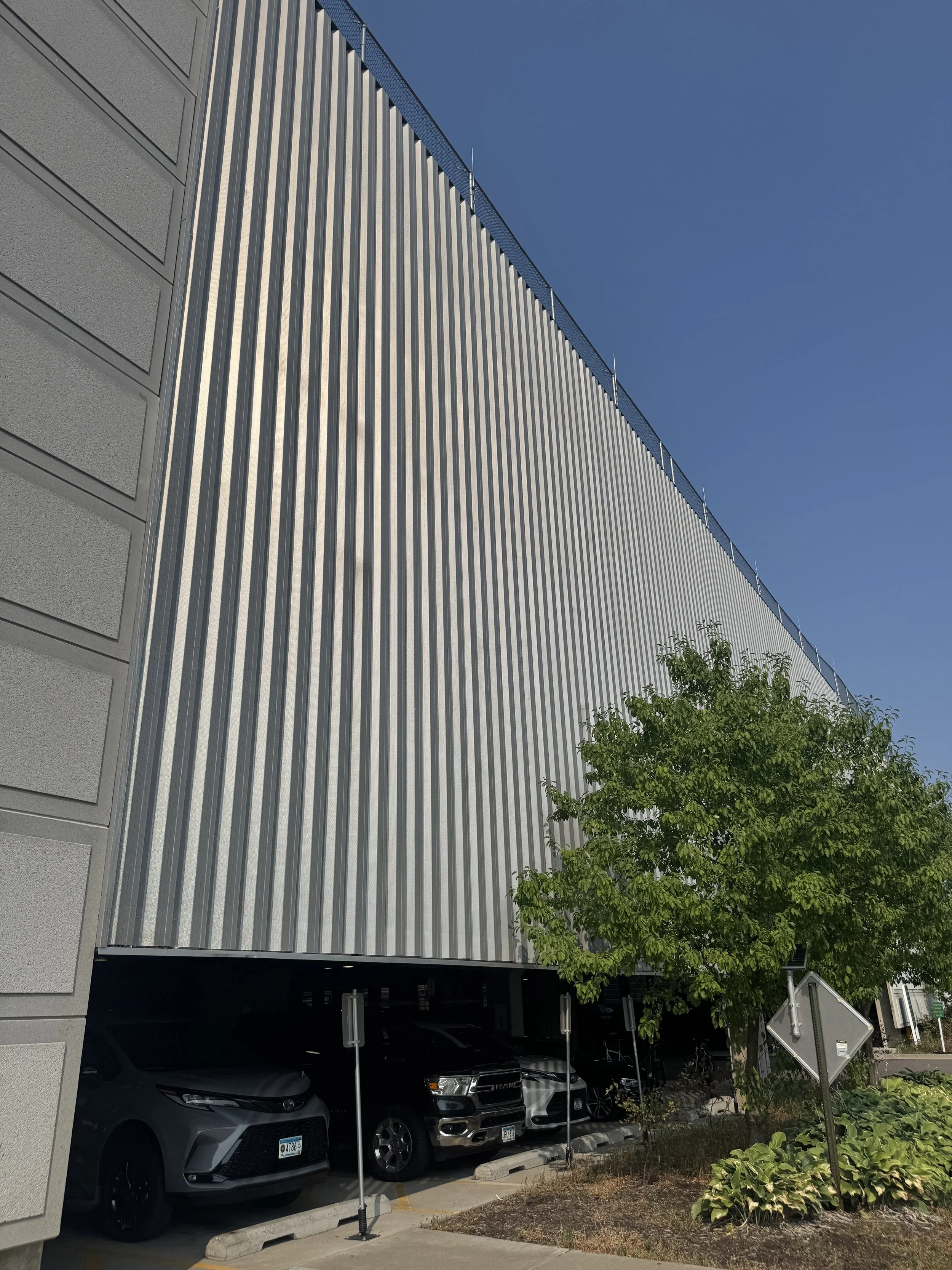 Exposed fastener perforated architectural single skin panels installed at the V.A. Medical Center Parking Ramp in Minneapolis, MN.