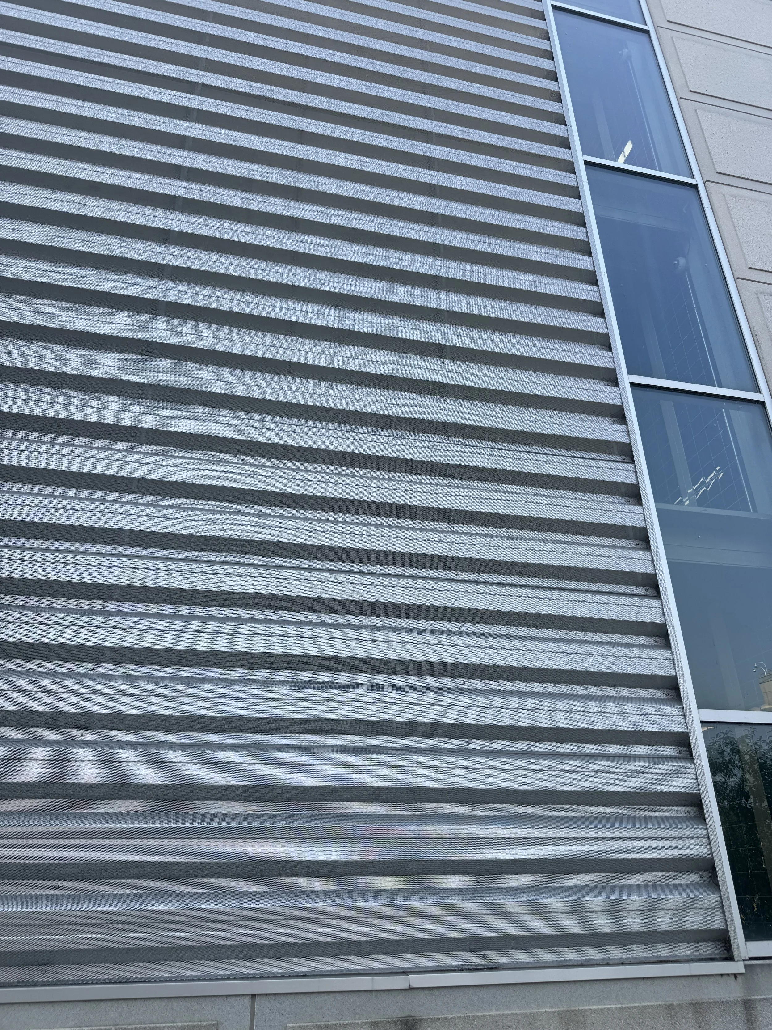 Exposed fastener perforated architectural single skin panels installed at the V.A. Medical Center Parking Ramp in Minneapolis, MN.