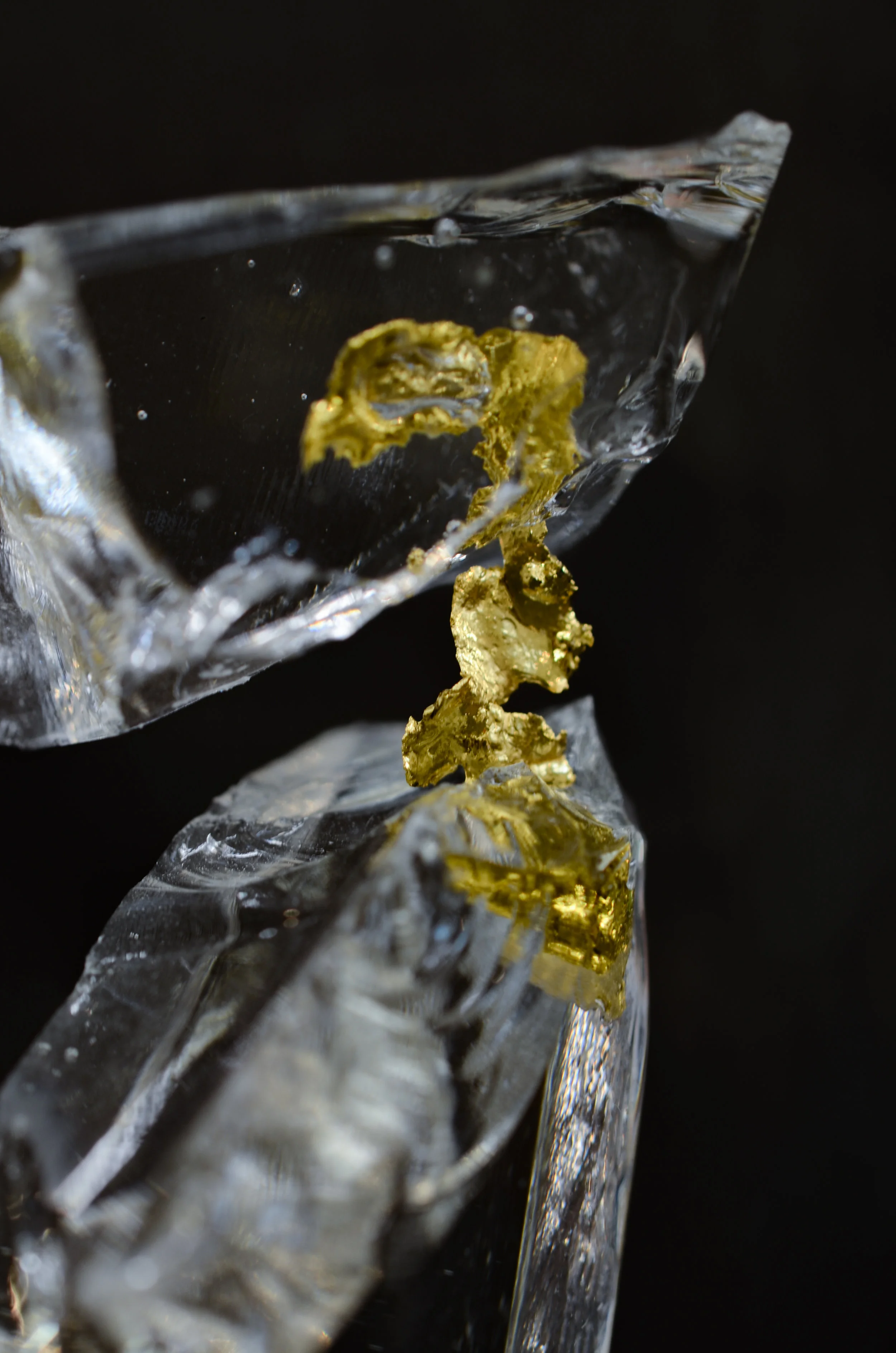 24K gold figure between two glass boulders