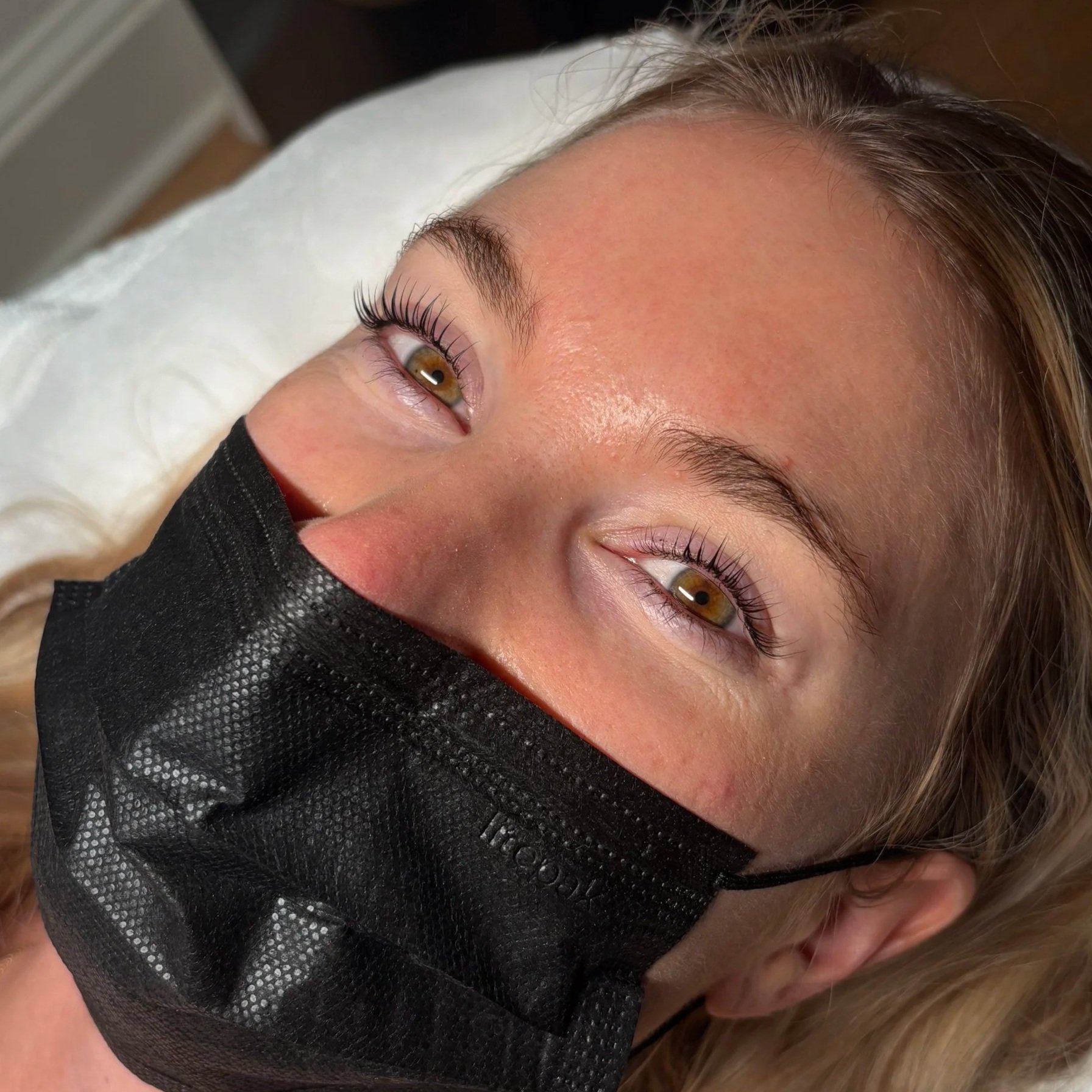 A woman with long blonde hair after receiving a lash lift or perm treatment at DC Lash Bar.