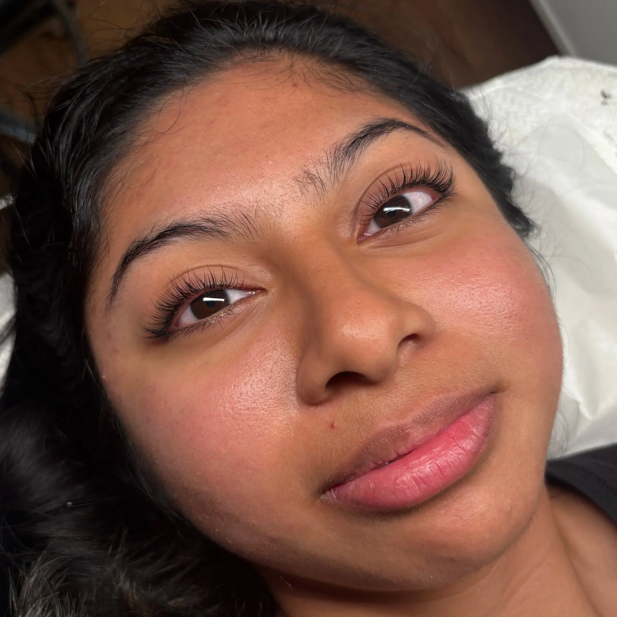 Close-up of a young woman with long eyelashes after receiving a lash lift or perm at DC Lash Bar.