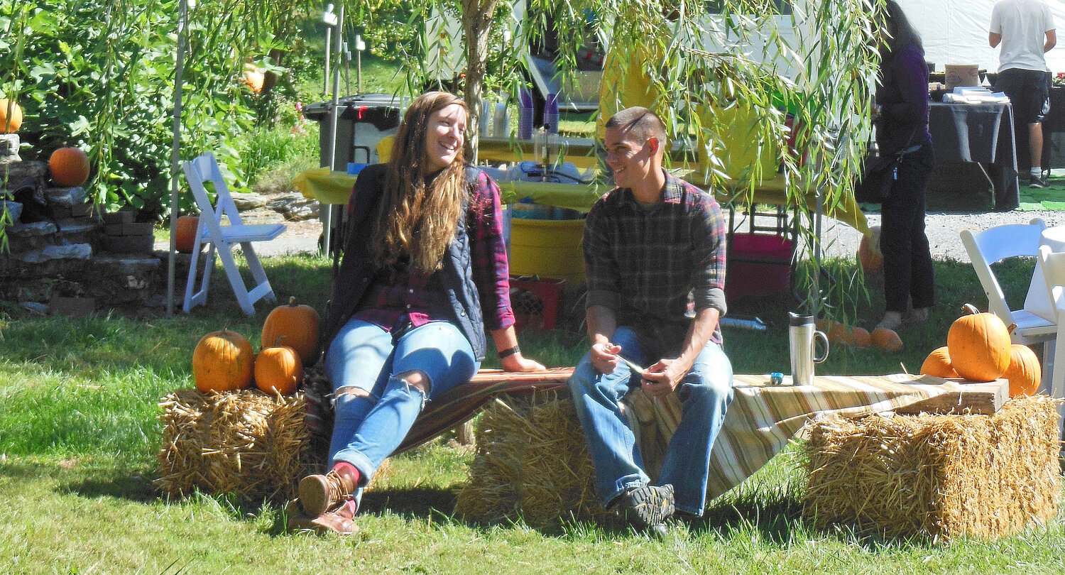 A couple relaxing by the greenhouses at our 2018 picnic