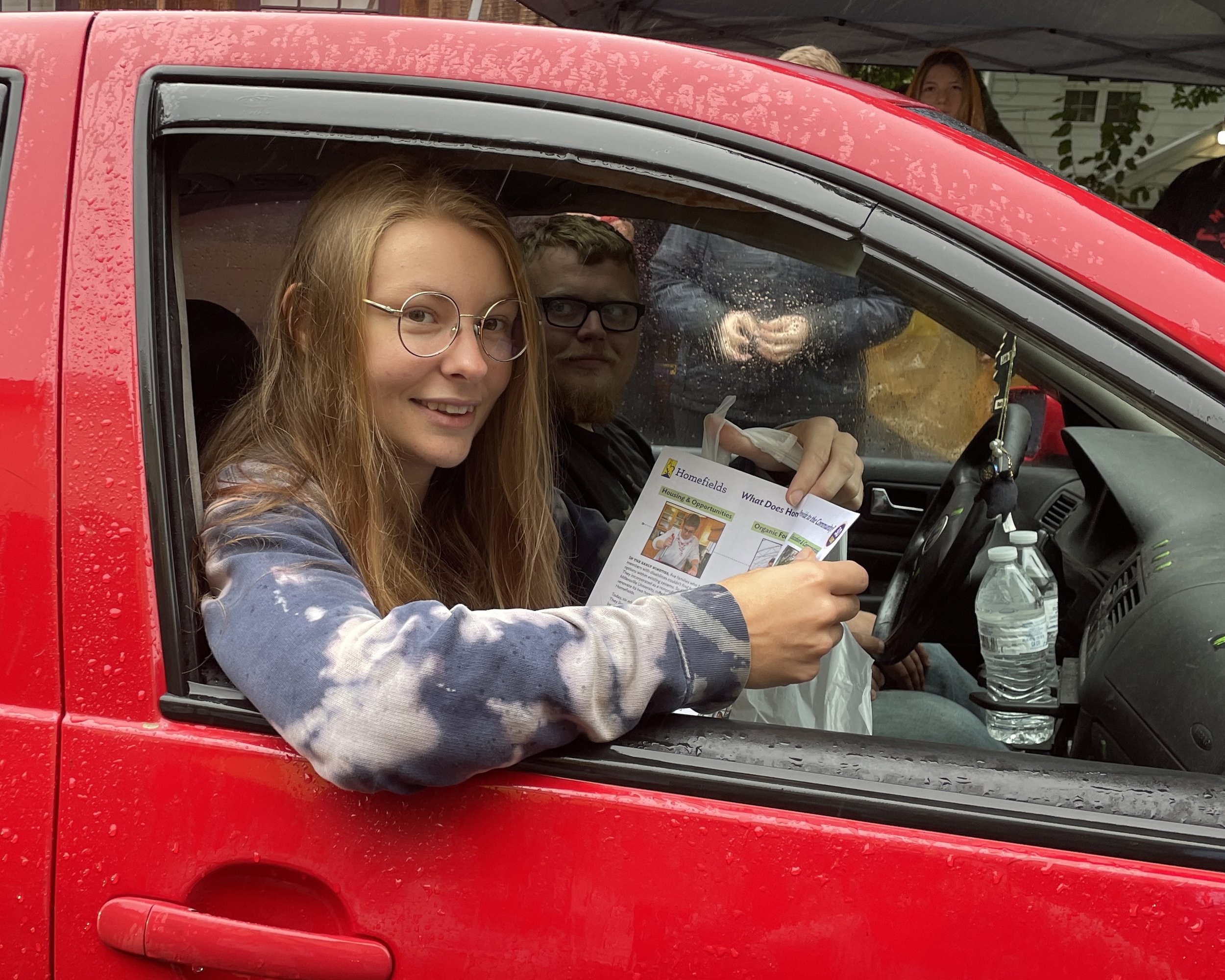 Lead Farmhand Alex Orr reviews the menu as volunteers prepare her take-home meal.