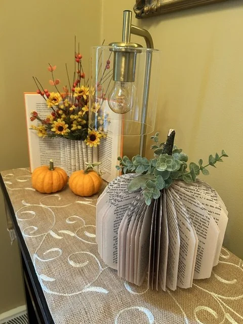  Two flower vases made from books; one open and the other a full circle. 