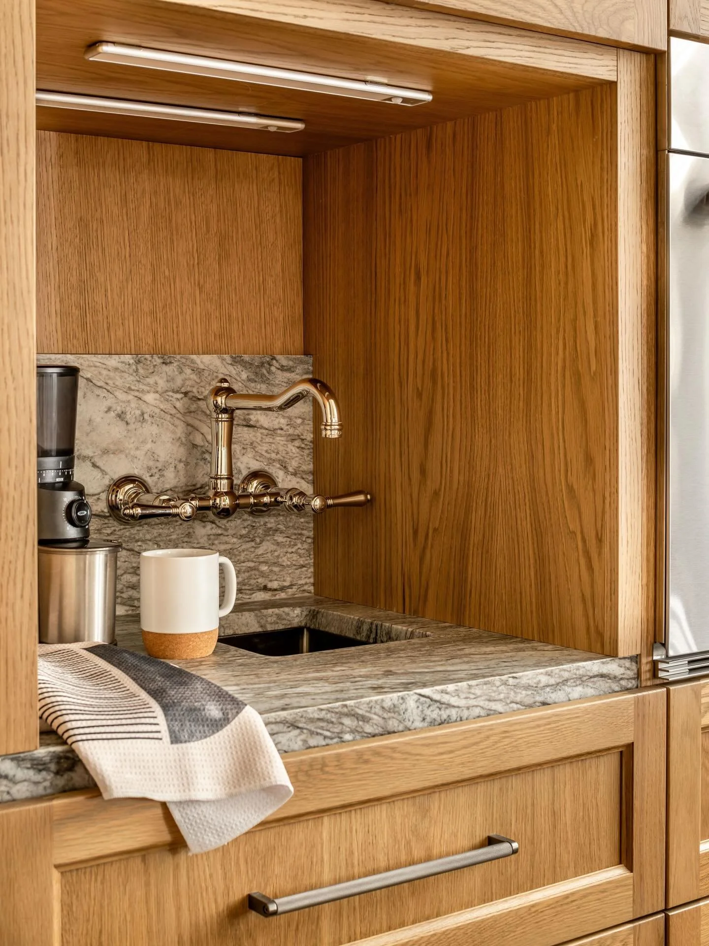 Behind closed doors: a fully concealed coffee station with rich wood tones, natural granite stone, and a sculptural Rohl faucet that elevates the everyday ritual ☕️ 

📸: @jeffherrphoto 
📖: @atlantahomesmag