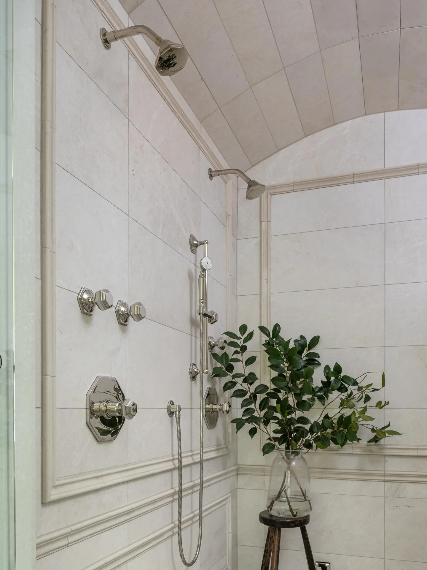 Soft neutrals, timeless details, and a little moment of calm 🌿

This primary shower was designed to feel both elevated and effortless&mdash;featuring classic wall panel detailing, layered stone, and polished nickel fixtures that bring just the right