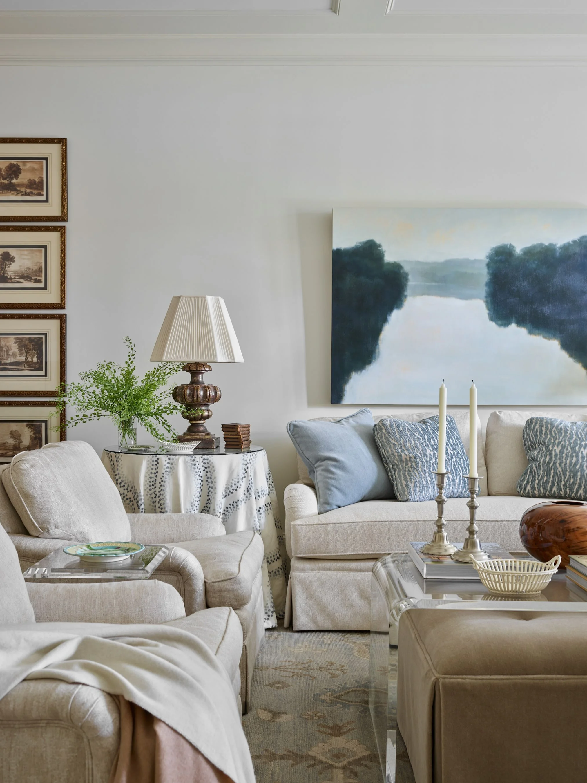 Designed to feel equal parts refined and welcoming, this formal living room is layered with soft textures, tonal neutrals, and collected pieces that bring warmth to the space. From the tailored upholstery to the moody landscape artwork and quiet patt