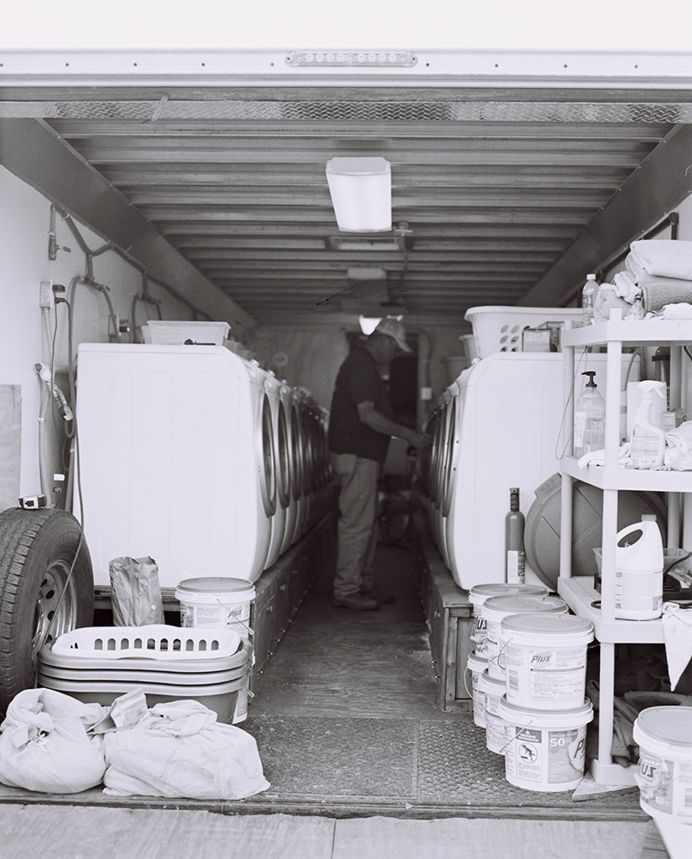 A laundry crew member checks the dryers.