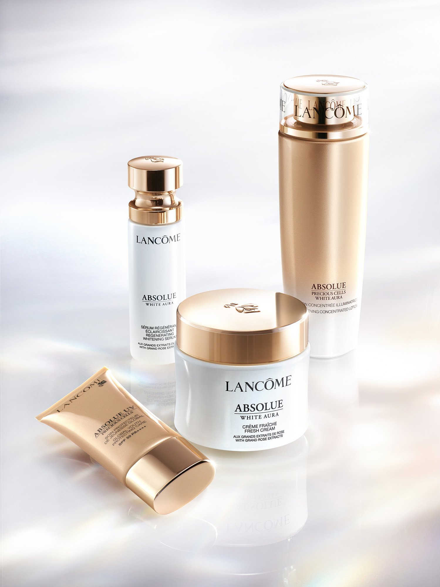 Lancôme Absolue White Aura serum, cream and lotion with Absolue UV on glossy white, product photography by Hiro