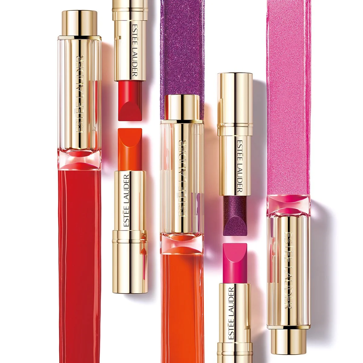 Estée Lauder Pure Color Love lipsticks in gold cases beside red, orange, purple and pink glitter swatches, lipstick photography by Hiro