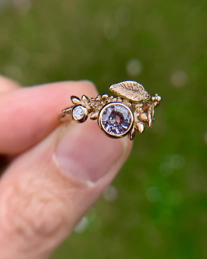 A forest ring made for a faerie. 🧚 Delicate lichens and buds frame a beautiful spinel and sapphire. I love spinels and all of their colours - especially muted tones like this lilac/grey. 
.
#spinelring #forestjewelry #naturejewellery #waxcarvingforj