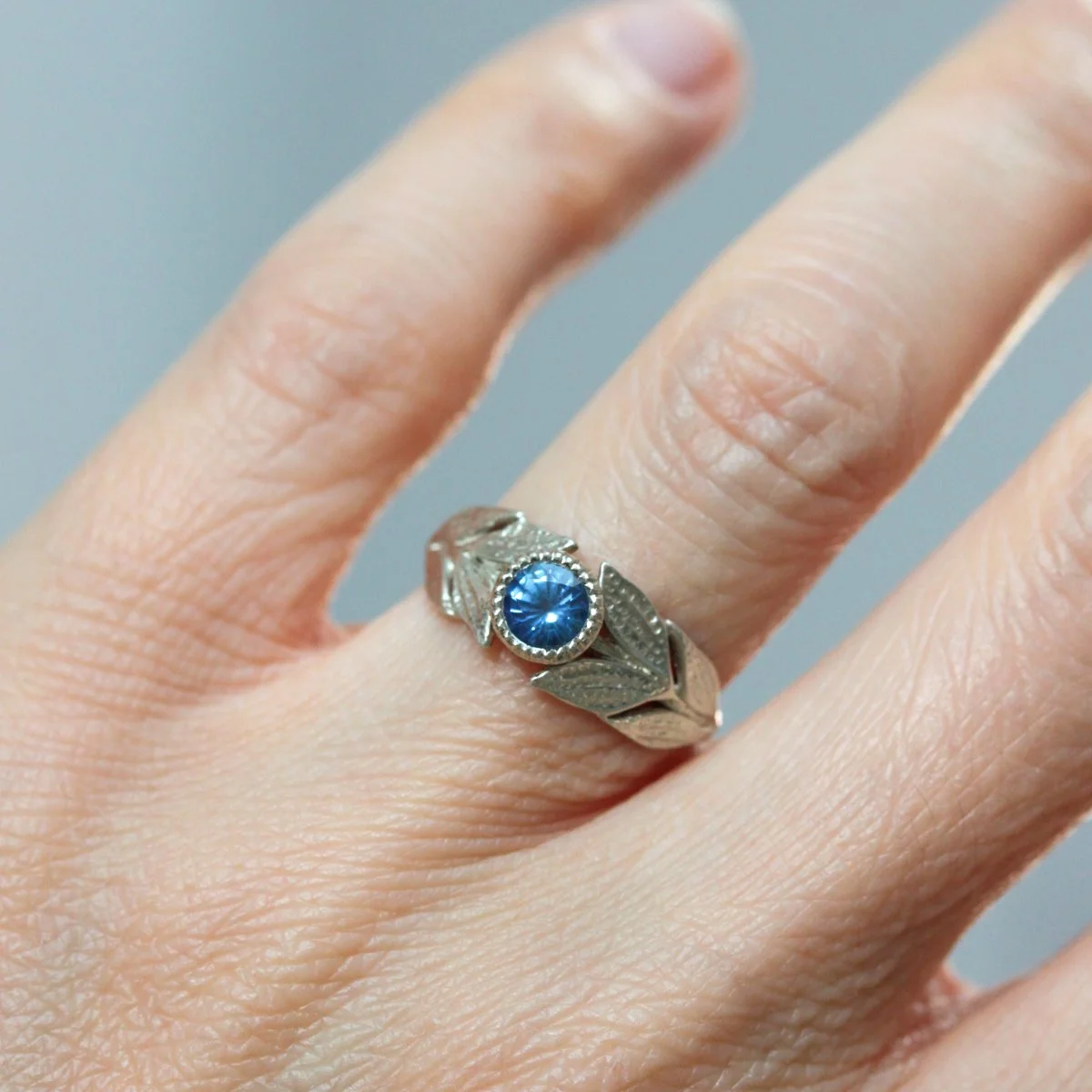 lily_blue_sapphire_engagement_ring_on_hand.jpg