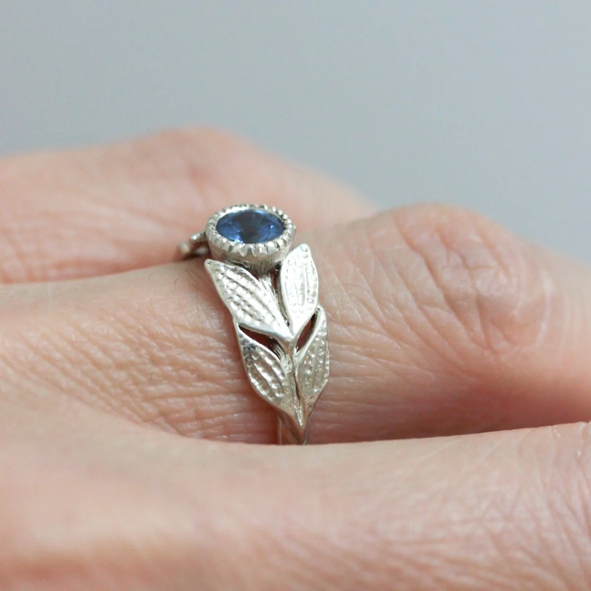 lily_blue_sapphire_engagement_ring_on_hand_1.jpg