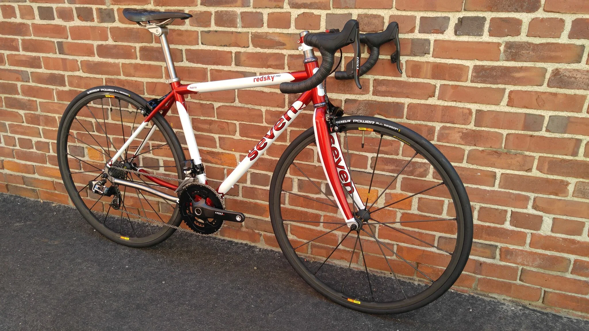 This is a Seven Cycles RedSky PRO. It boasts 32c Teravail Lickskillet tires, and SRAM eTap grouppo. The frameset is titanium lugs with carbon tubeset for a very lightweight, silky smooth ride. 
